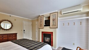 A bedroom with a bed, dresser, mirror, fireplace, and a closet. - The Birch Ridge: English Gentleman's Room #9 - King Suite in Killington, Vermont. Hot Tub. (Killington)