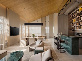 Una sala de estar moderna con techo de madera, televisor de pantalla plana, comedor y cocina con una isla de mármol.