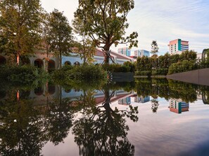 A tranquil water body reflecting buildings and trees, surrounded by greenery. - Mondrian Singapore Duxton (Singapore)