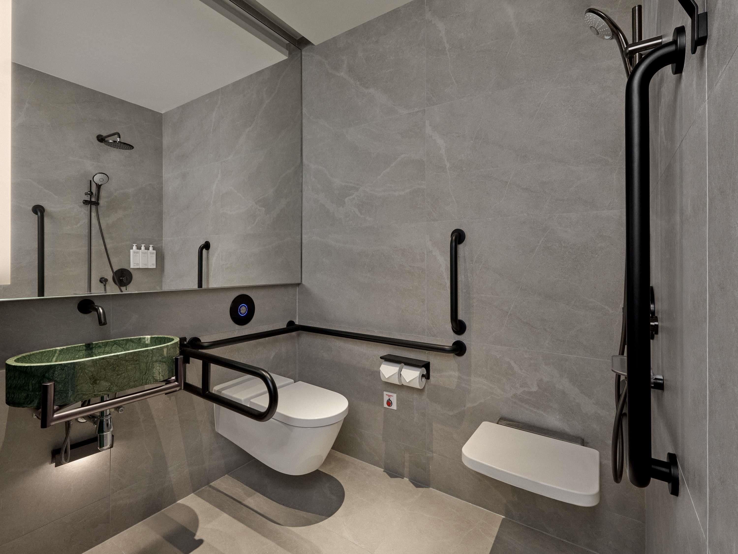 Et moderne badeværelse med toilet, bidet og bruser.