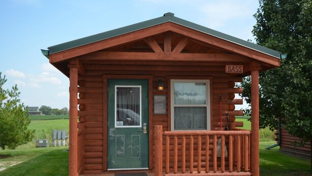 A small wooden cabin with a green door, a window, and a sign that reads "BASS". - Bass - sleeps up to four (Moravia)