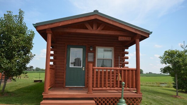 A small wooden cabin with a green door and a sign that reads "WALLEYE". - Walleye -  Sleeps up to Five (Moravia)