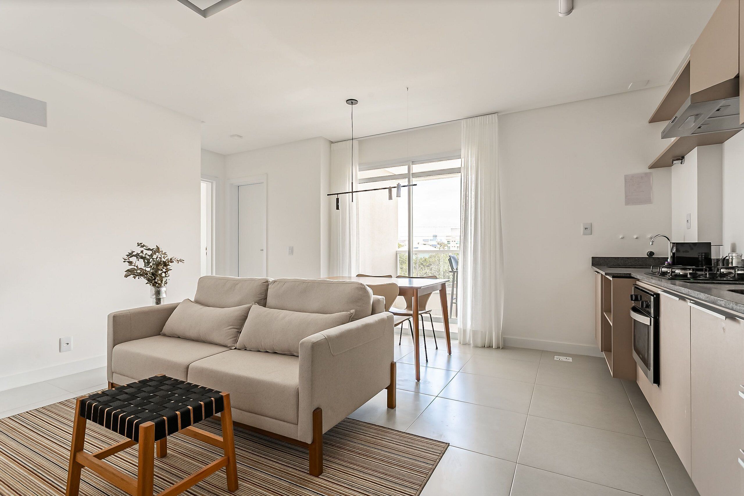 Eine moderne Wohnung mit Wohnbereich, Küchenzeile und Essbereich.