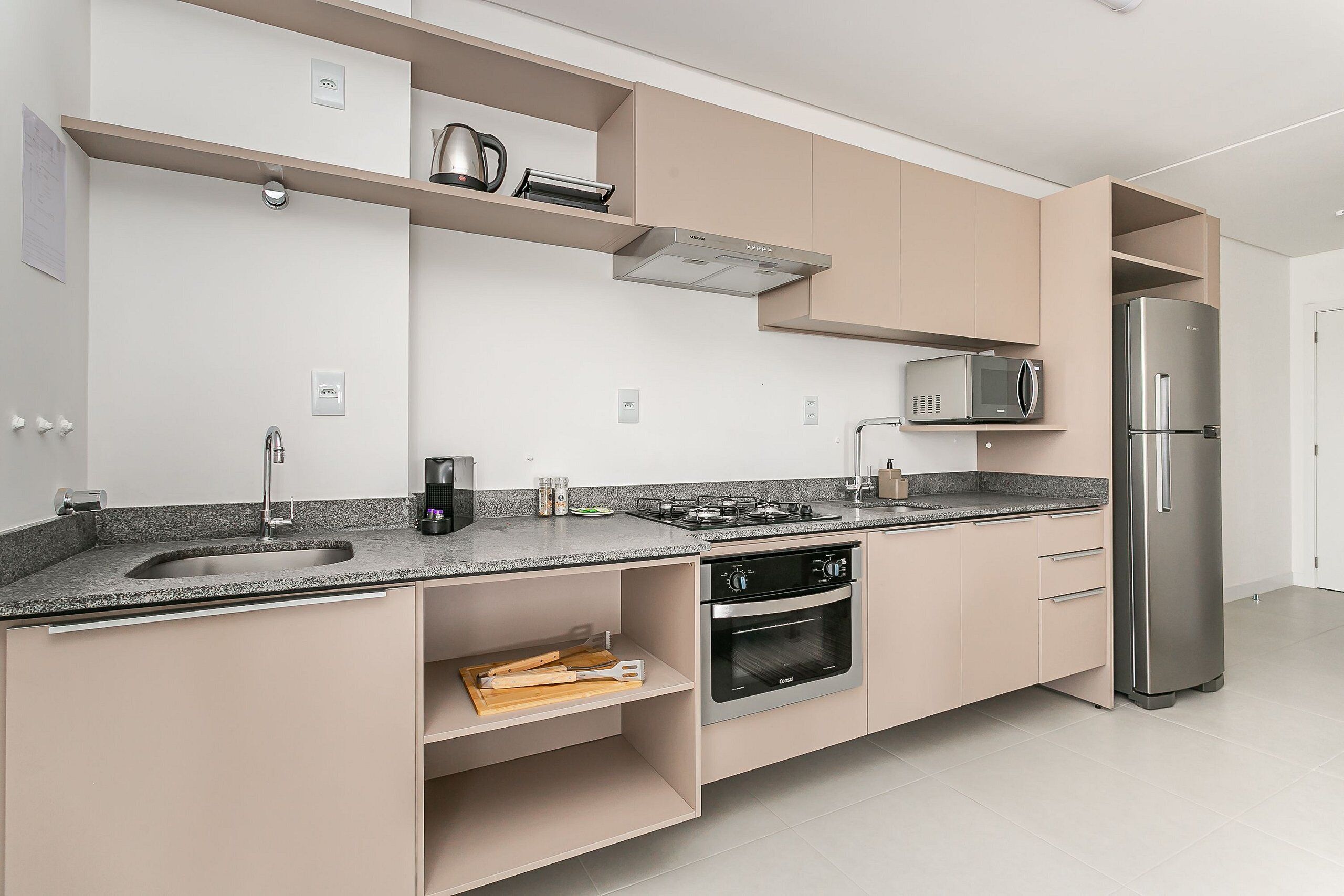 Eine moderne Küche mit Edelstahl-Kühlschrank, Einbauofen und Mikrowelle.