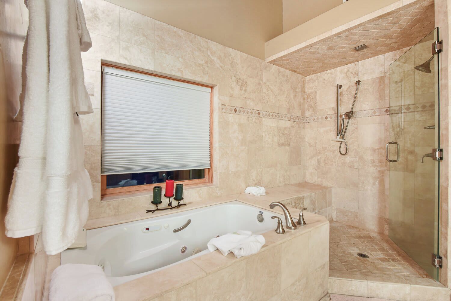 Une salle de bain moderne avec une baignoire sur pieds, une douche à parois de verre et une fenêtre équipée de stores.