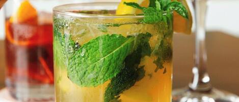 Un verre de thé glacé, garni de feuilles de menthe et d’une tranche de citron.