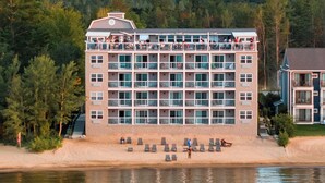 A multi-story hotel with balconies, a beachside location, and a view of the water. - Alexandra Inn (Traverse City)