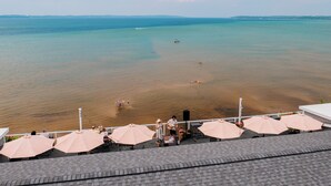 A beach view with umbrellas and a person playing guitar. - Alexandra Inn (Traverse City)