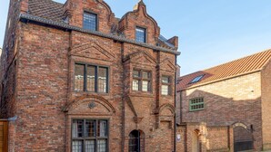 A historic brick building with arched windows and a traditional design. - The Dutch House -  a family break that sleeps 4 guests  in 2 bedrooms (York)