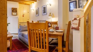 A cozy dining area with wooden furniture, a red patterned rug, and framed pictures on the wall. - The Dutch House -  a family break that sleeps 4 guests  in 2 bedrooms (York)