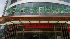 A hotel with a modern glass facade and signage in a foreign language. - Greentree Inn Wuxi New District High Speed Rail Station Newland Family Express Hotel (Wuxi)