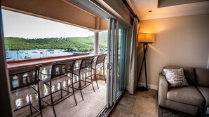 Ein Balkon mit Stühlen, einem Tisch, einer Couch und einer Lampe.