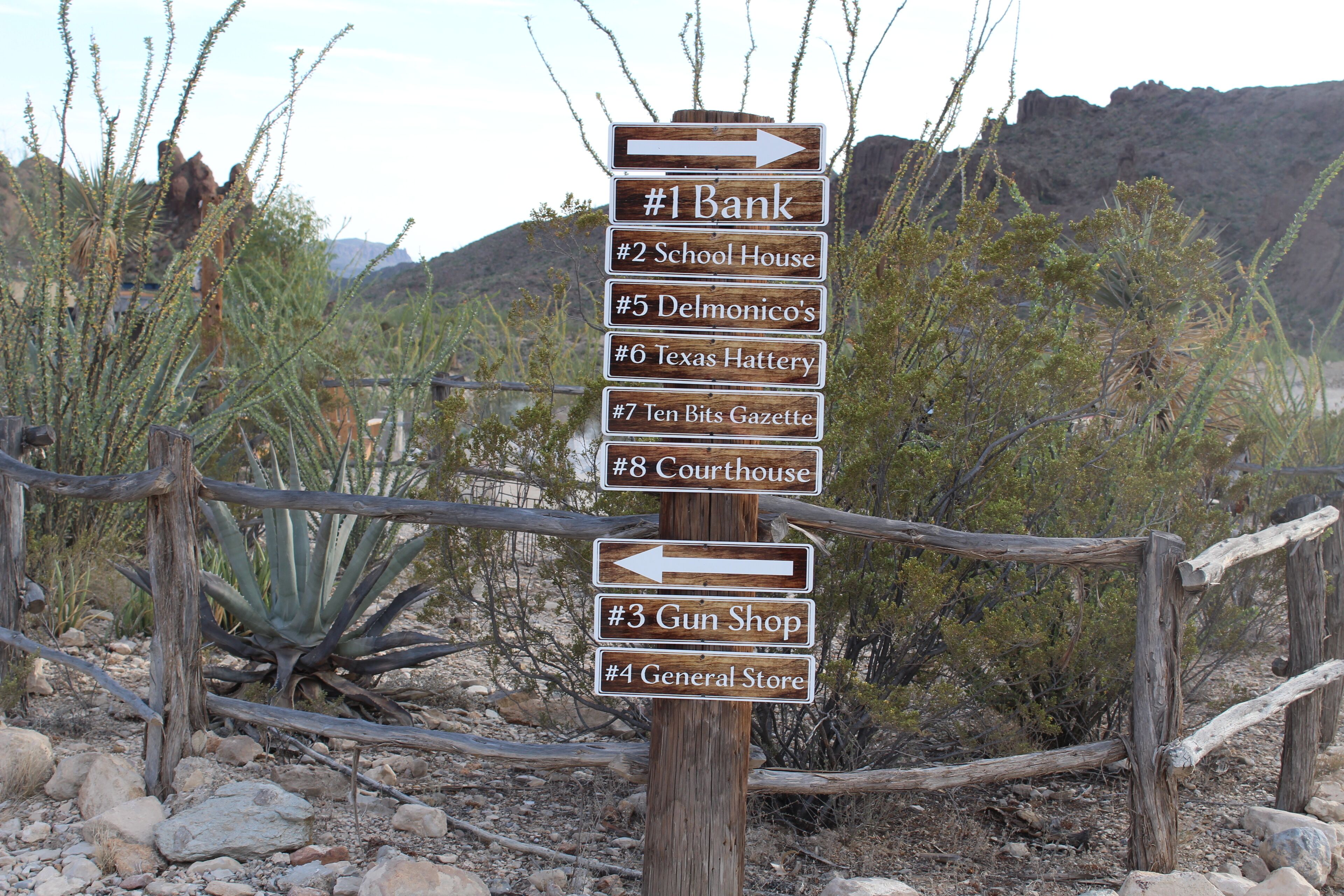 A directional signpost with arrows pointing to various local businesses.