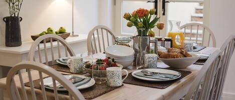Enjoy a delicious breakfast in this inviting dining area, complete with a beautifully set table and fresh flowers.