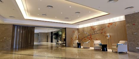 A modern lobby with a polished marble floor, recessed lighting, and contemporary furniture.