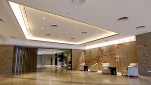 Een moderne lobby met een gepolijste marmeren vloer, inbouwverlichting en modern meubilair.