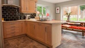 Una cocina moderna con armarios de madera, protector contra salpicaduras de azulejos y una isla grande con asientos.