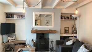 Un salon confortable avec une cheminée, un téléviseur et une bibliothèque.