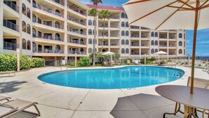 A hotel with a pool, multiple balconies, and outdoor seating. - 417 Seascape by Avantstay Beachfront Condo w/ Communal Pool Access (Isle of Palms)