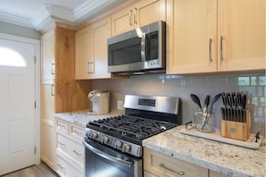 Enjoy cooking in this fully equipped kitchen with a stainless steel range, oven, microwave, and coffee maker.