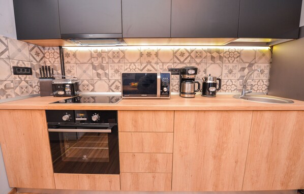 Eine moderne Küche mit Mikrowelle, Kaffeemaschine und Backofen.
