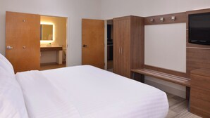 A hotel room with a bed, wooden wardrobe, a mirror, and a TV. - Holiday Inn Express Olean (Olean)