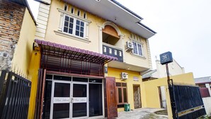 A two-story building with a yellow facade, a balcony with a red railing, and a sign indicating 'OYO LIFE'. - OYO 91199 Felicia Homestay (Medan)