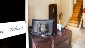A room with a desk, a television, a fan, and a staircase. - OYO 91199 Felicia Homestay (Medan)