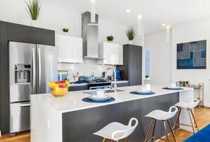 Enjoy cooking in this well-equipped kitchen with a central island, stainless steel appliances, and ample counter space.
