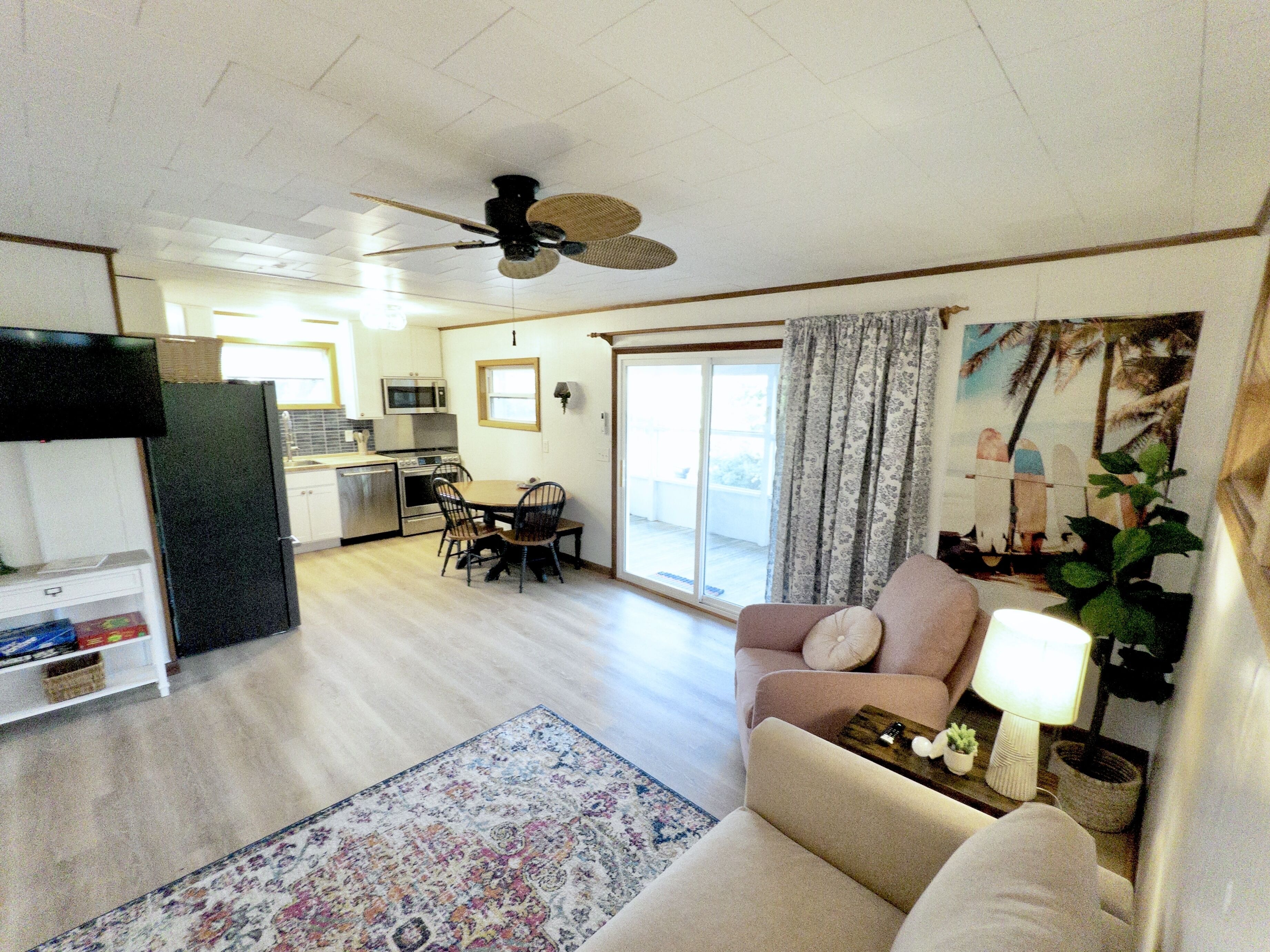 A spacious living area with a sofa, a dining table, and a kitchen in the background.