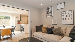 Ein modernes Wohnzimmer mit einer Couch, einem Couchtisch und Kunstwerken an der Wand.