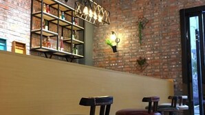 A cozy bar area with a brick wall, shelves with bottles, and a wooden bench. - Pian an Yi Yu (Chizhou)