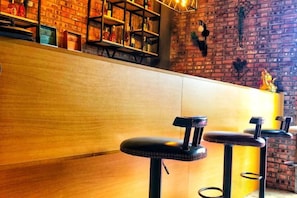 A bar area with wooden counters and black stools. - Pian an Yi Yu (Chizhou)