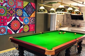 A pool table with balls, a colorful wall art, and a television. - Pian an Yi Yu (Chizhou)