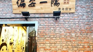 A brick wall with a wooden sign above a glass door. - Pian an Yi Yu (Chizhou)