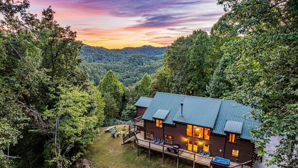 Een chalet met terras, buitenzitplaatsen en uitzicht op het omliggende bos.