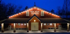 Flat Rock Playhouse features a pitched roof and columns, with a welcoming entrance and door.