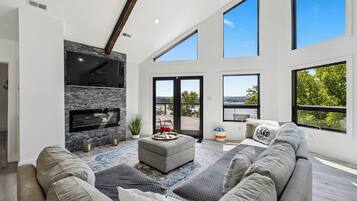 TV connectée, cheminée, livres, écrans d'ordinateur