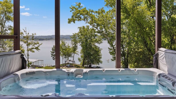 Een hottub met uitzicht op een meer en bomen.