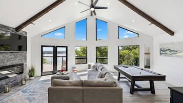 TV connectée, cheminée, livres, écrans d'ordinateur