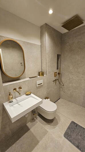 Apartamento Deluxe | Baño | Ducha, cabezal de ducha tipo lluvia, secador de pelo y toallas