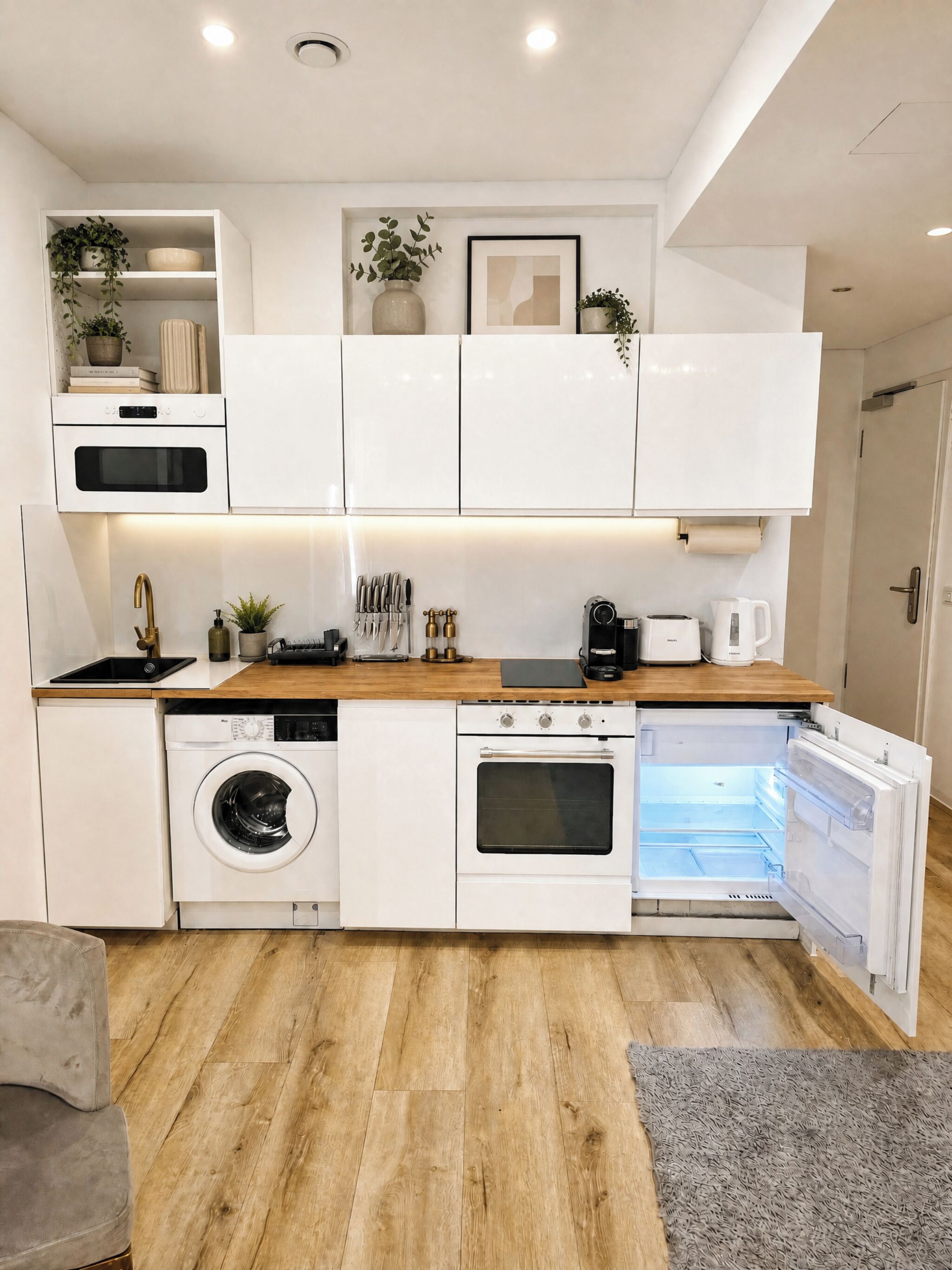 Een moderne keuken met inbouwapparatuur, een houten aanrecht en een grijze vloerkleed.