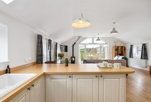 A spacious kitchen with a central island, white cabinetry, and a large window providing natural light.