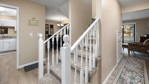 A home interior with a staircase, kitchen, and living area. - Pointe Royale, Step Free Entry, Indoor Pool (Branson)