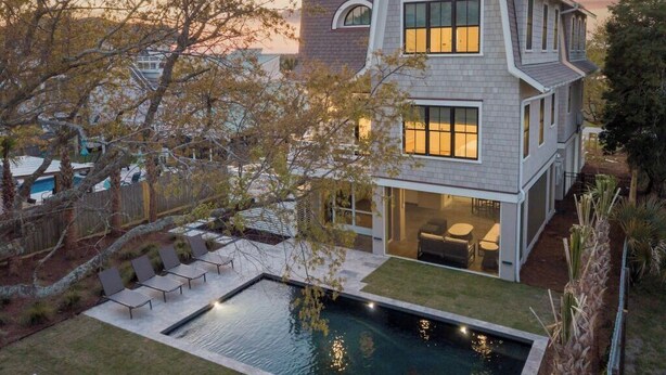 Une maison moderne à deux étages, dotée d’une piscine, d’un espace extérieur aménagé et d’un jardin bien entretenu.