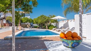 A swimming pool with lounge chairs and a bowl of oranges. - Finca El Aulagar Alhaurín el Grande by Ruralidays (Málaga)