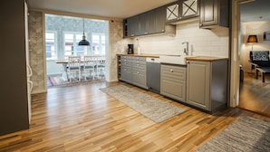 Eine moderne Küche mit grauen Schränken, einer Holz Arbeitsplatte und einem integrierten Geschirrspüler.
