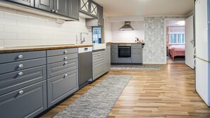 Eine moderne Küche mit grauen Schränken, einem eingebauten Backofen und einer Holz Arbeitsplatte.