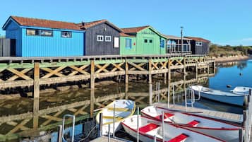 Un muelle de madera con edificios coloridos, barcos amarrados y agua tranquila.