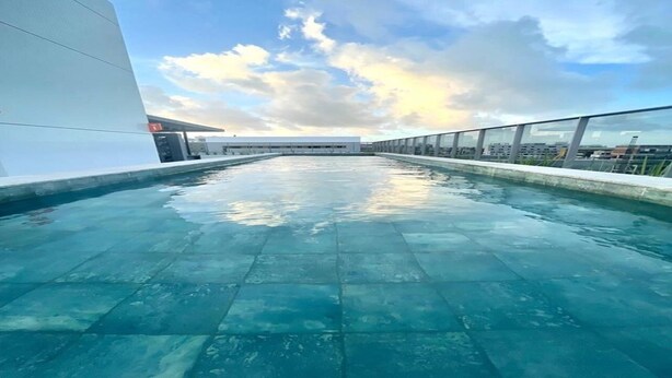 Piscina no terraço com vista clara para o horizonte da cidade.